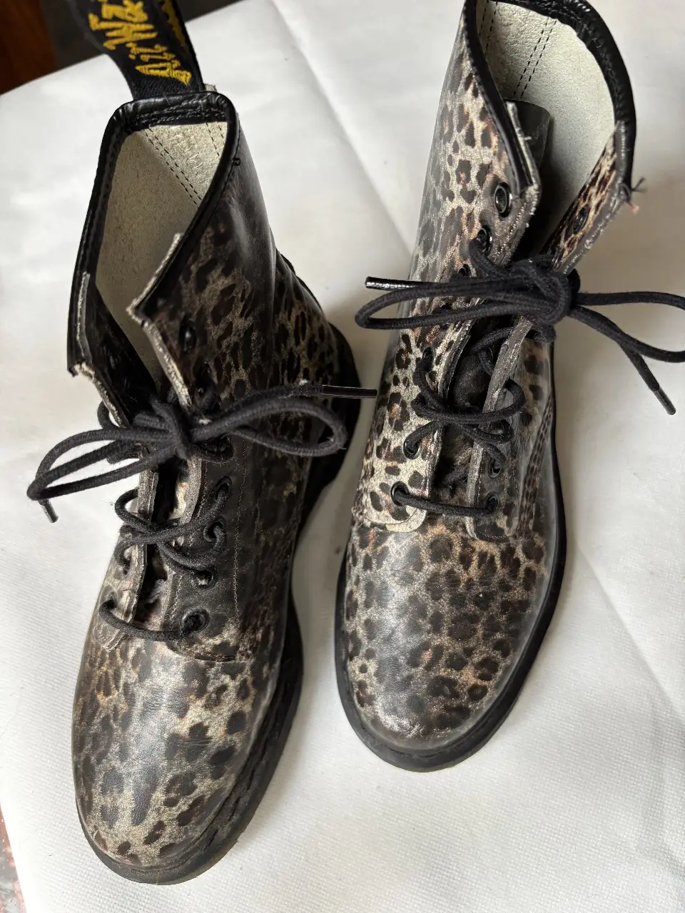 Botines Dr. Martens con estampado de leopardo. Cordones negros y suela negra.