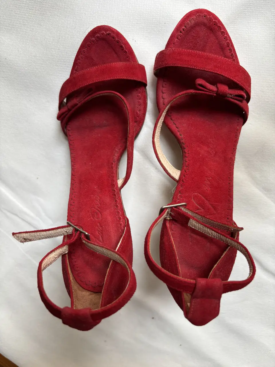 Sandalias LAS OREIRO rojas de gamuza con detalles de moño y pulsera al tobillo. Ideales para un look elegante y femenino.
