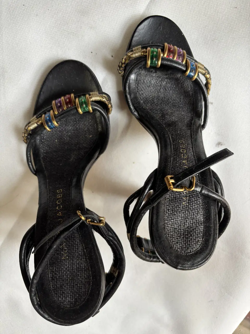 Sandalias MARC JACOBS tacón alto negras con detalles dorados y apliques de colores en la tira delantera. 