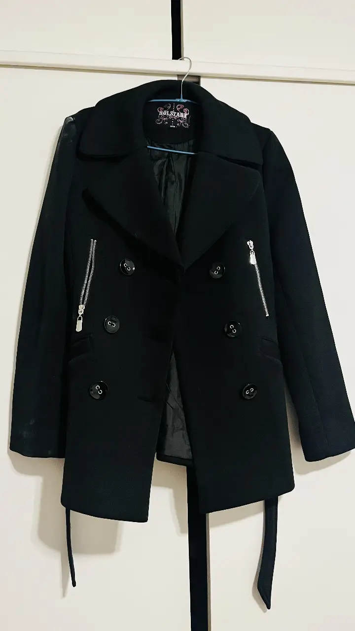 Tapado negro de paño, estilo peacoat, con botones y bolsillos con cierre. Ideal para el invierno, un clásico que no puede faltar en tu guardarropa.