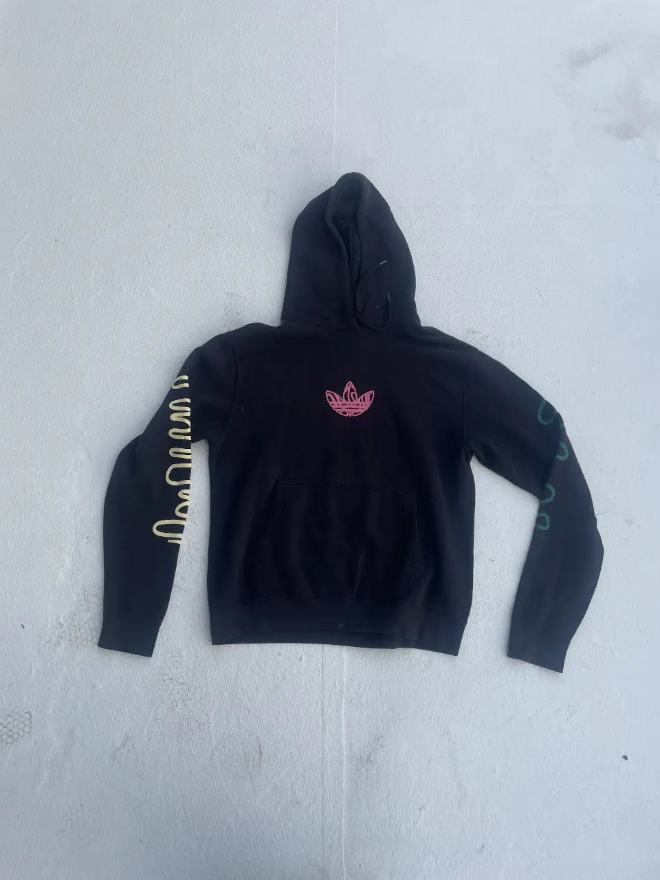 Buzo canguro negro con estampado en mangas y pecho. Diseño moderno y urbano, ideal para un look casual y cómodo.