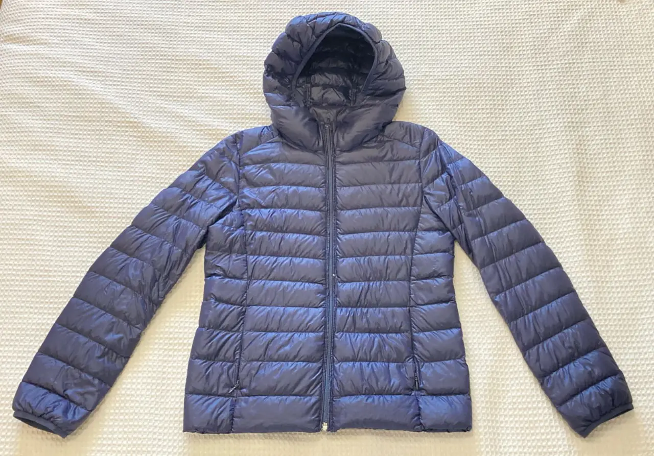 Campera de pluma azul marino, ultra liviana y con capucha. Ideal para el invierno, fácil de guardar en su bolsa.