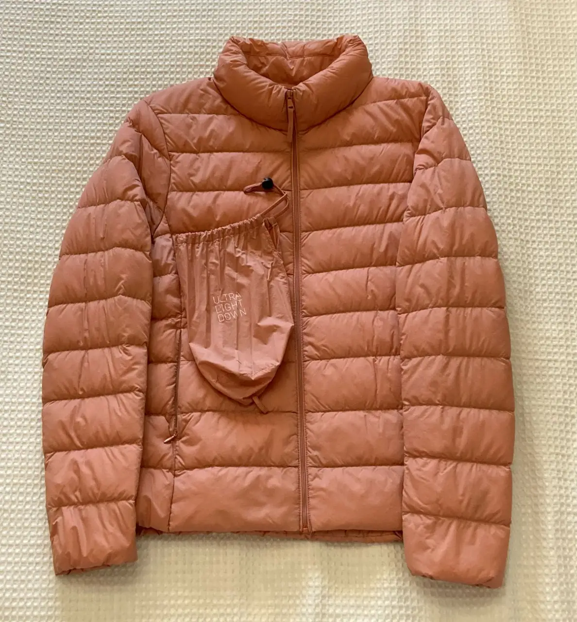 Campera de pluma ultra liviana de la marca Uniqlo, color rosa. Ideal para el invierno, es compacta y fácil de guardar. Talle S.