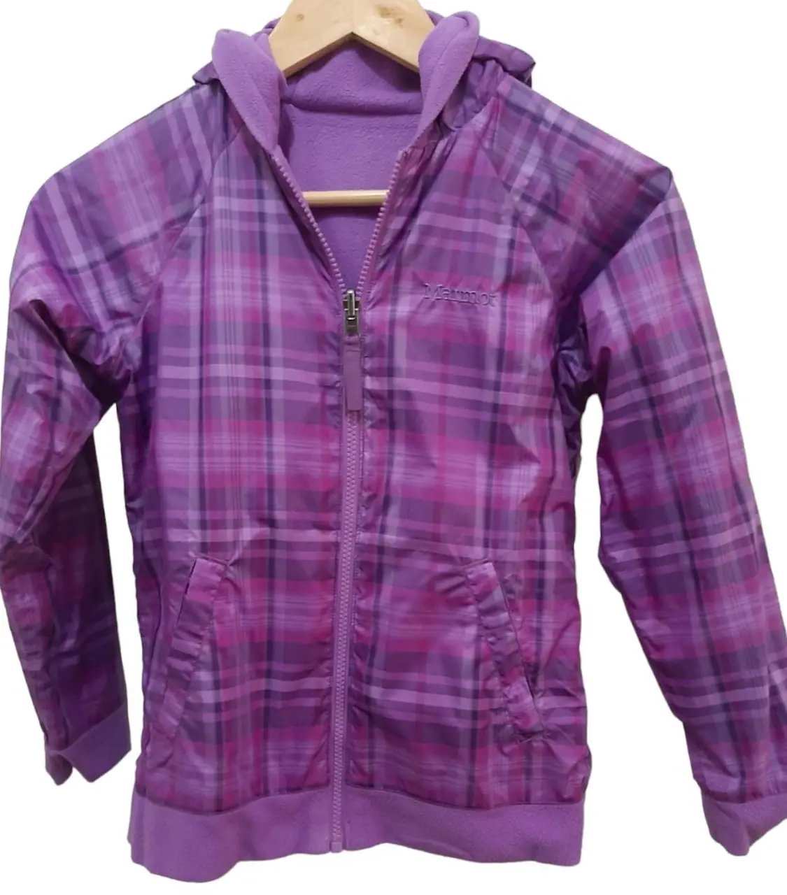 Campera reversible para niña, con capucha y cierre. Un lado es de polar liso violeta y el otro lado es una tela con estampado a cuadros en tonos violetas. Ideal para el frío. Sisa 42 cm, mangas 51 cm, largo 55 cm.