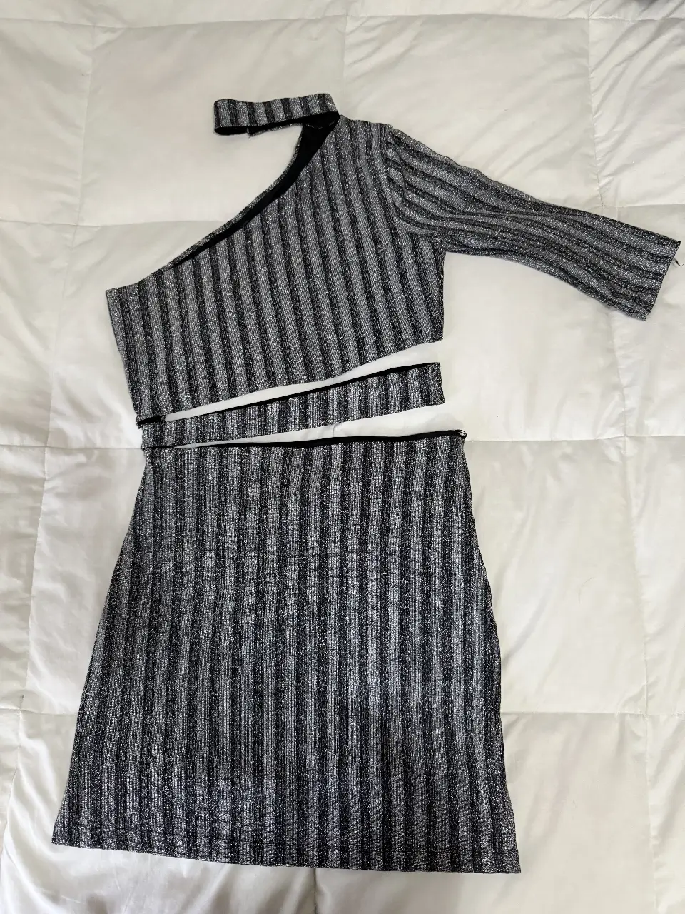 Conjunto de dos piezas de fiesta, con top asimétrico de un solo hombro y falda a juego. Confeccionado en tela brillante con rayas verticales.