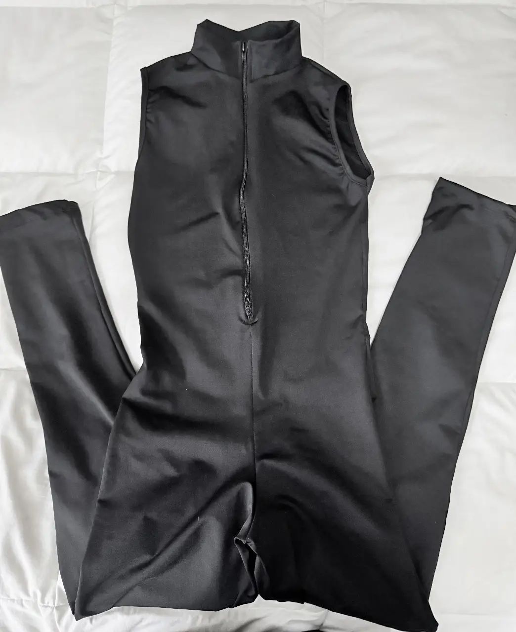 Mono largo deportivo de color negro, sin mangas y con cierre frontal. Ideal para actividades físicas o para un look moderno y cómodo.