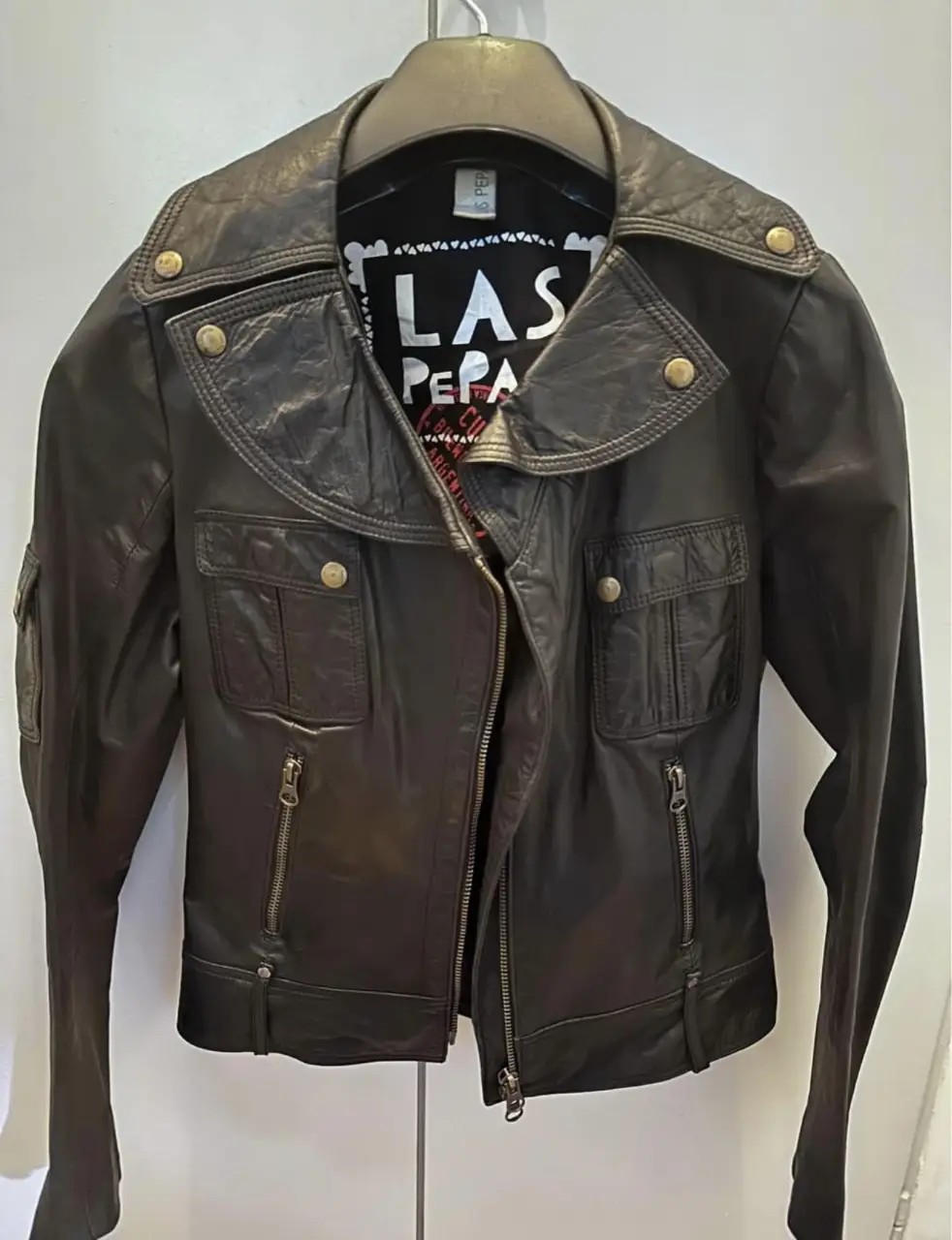 Campera de cuero negra estilo biker de la marca Las Pepas. Confeccionada en cuero de alta calidad, presenta un diseño clásico con detalles de cremalleras y bolsillos funcionales. Ideal para un look rocker y moderno. cuero vacuno 100%