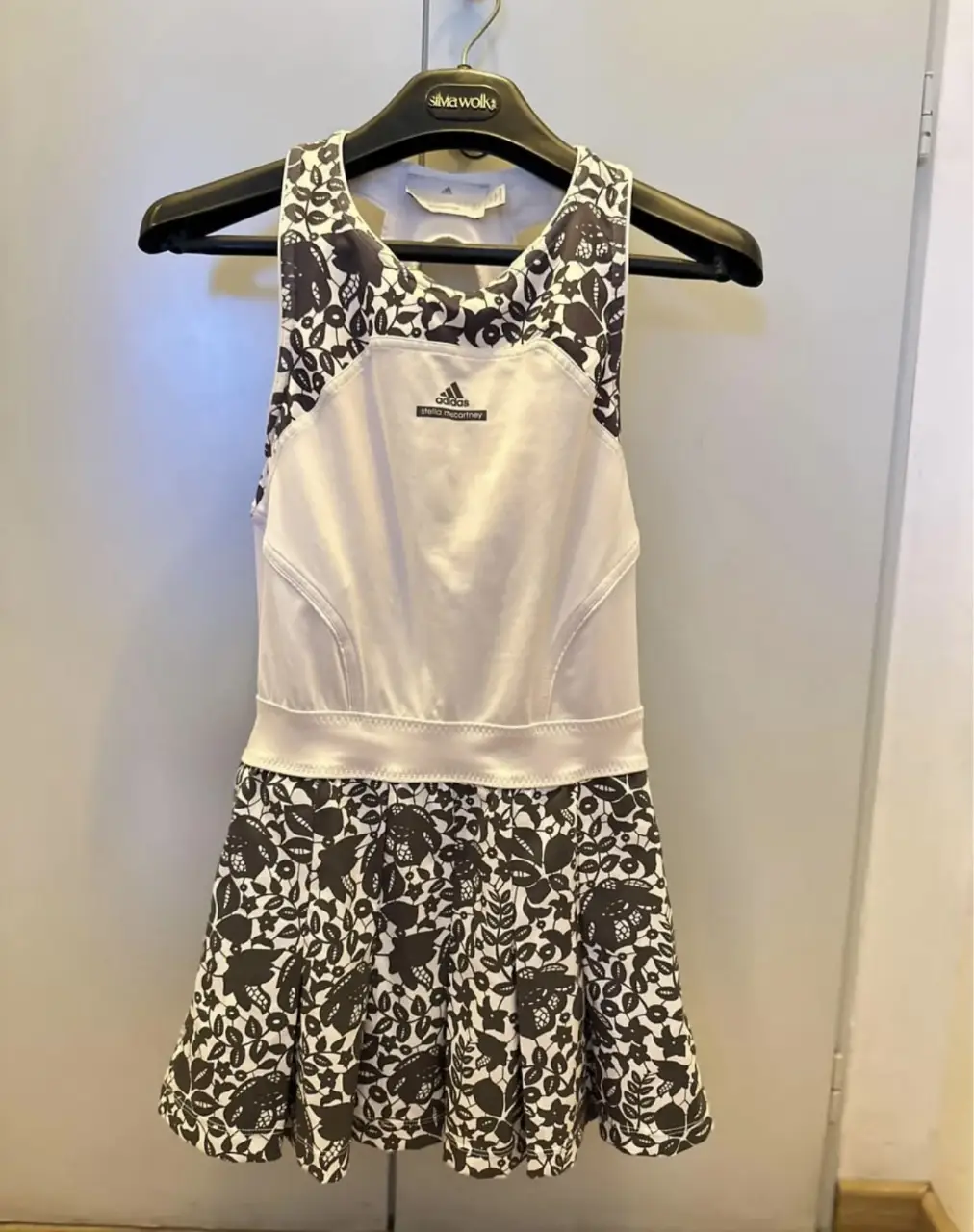 Vestido deportivo Adidas Stella McCartney Barricade, con estampado floral en la falda y detalles en blanco. Ideal para tenis o actividades deportivas. Original.