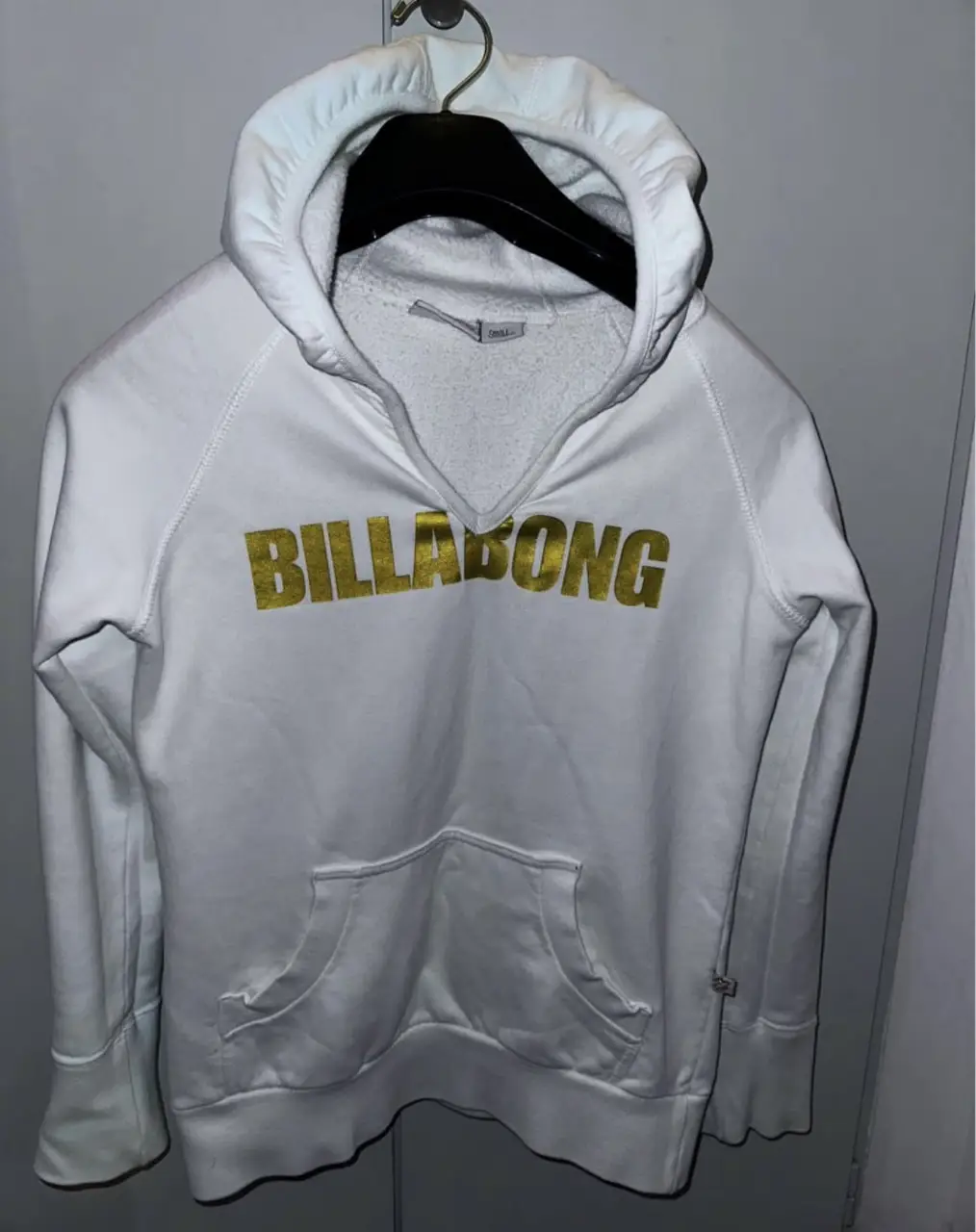 Buzo canguro Billabong blanco con logo dorado. Talle small. Ideal para un look casual y cómodo. Original 