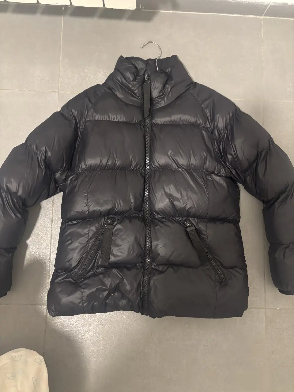 Campera de pluma negra, ideal para el invierno. Con cierre frontal, bolsillos con cierre y cuello alto. Marca Koxis, talle S.