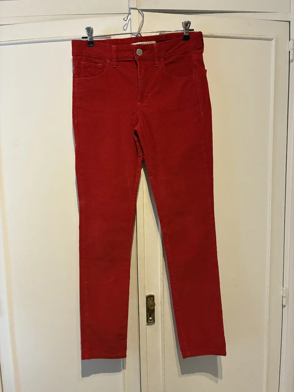 Pantalón de corderoy rojo, tiro medio, con bolsillos delanteros y traseros. Marca AWADA. Talle 26.