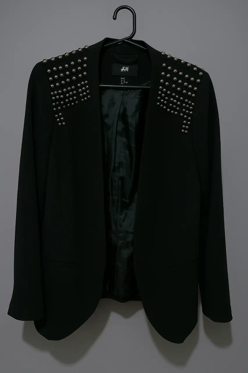 Elegante blazer de H&M negro de mujer con detalles de tachas plateadas en los hombros. Ideal para un look sofisticado y moderno.