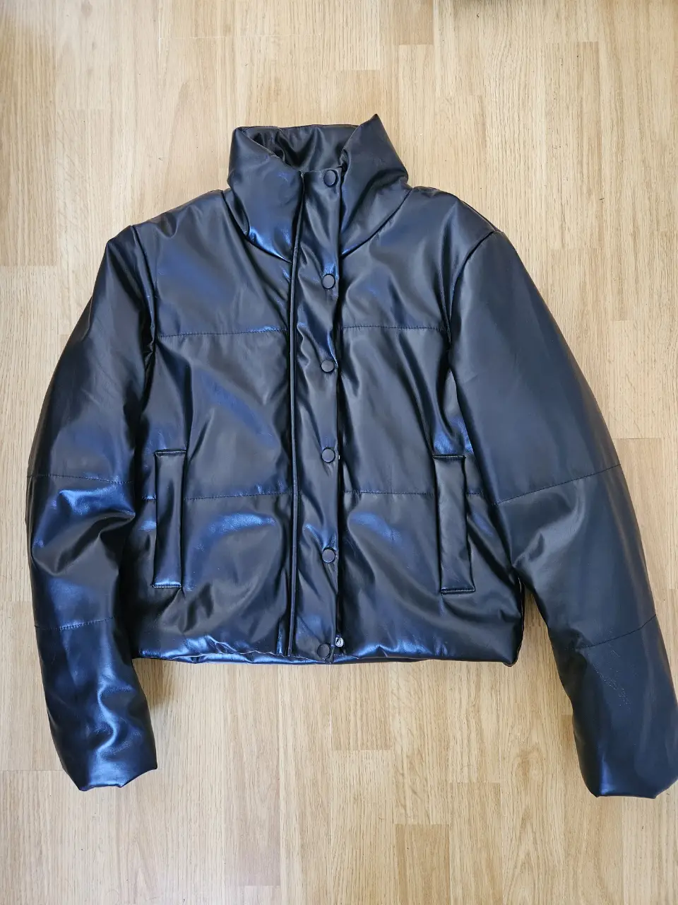 Campera puffer de cuero sintético negra, con cuello alto y cierre. Forrada, super abrigada. Medidas: hombros 42cm, sisa 48cm, largo 54cm, magas 64cm.