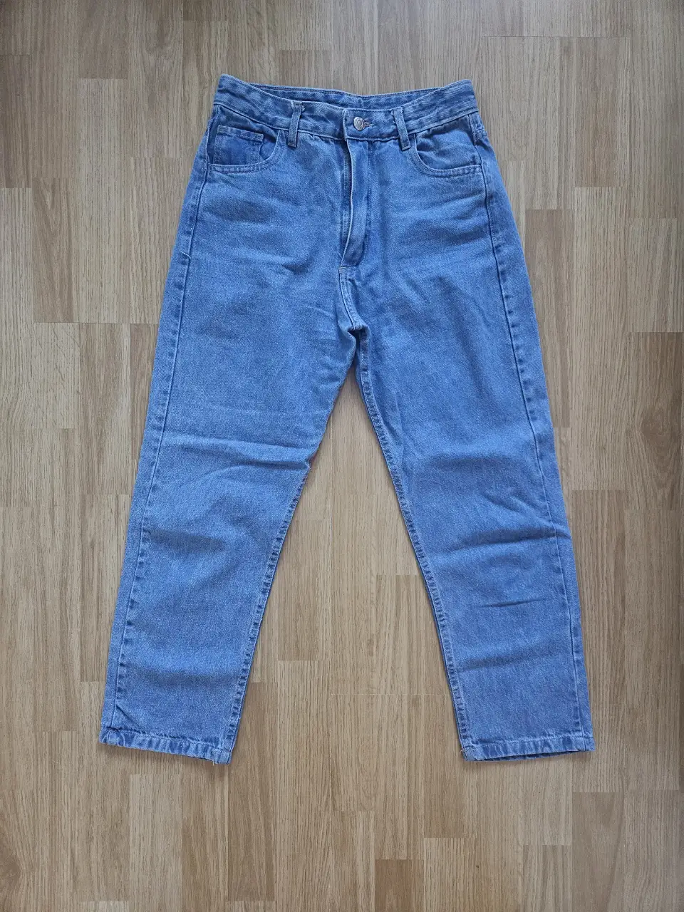 Mom jean de denim azul claro y tiro medio. Un básico atemporal para cualquier guardarropa. Medidas con prenda apoyada: Cintura 34cm, Tiro 26cm, Cadera 48cm aprox, Largo 90cm