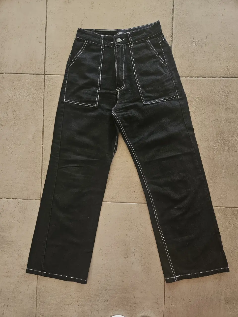Pantalón negro de jean con costuras blancas. Talle 36. Estilo casual y utilitario. Ideal para un look streetwear. Medidas con prenda apoyada: Cintura 32cm, Tiro 30cm, Cadera 47 aprox, Largo 98cm