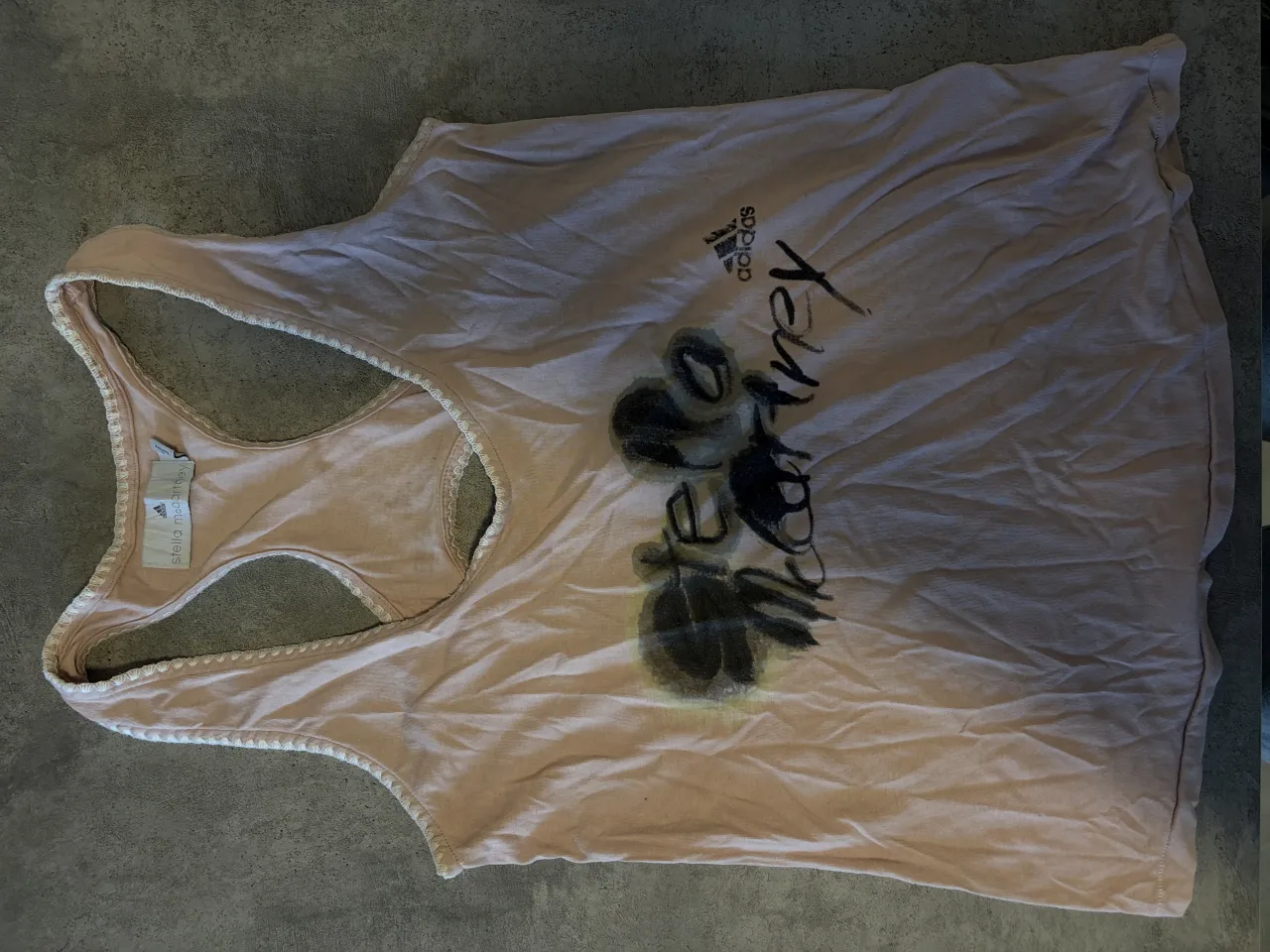 Musculosa deportiva rosa pálido con estampa "Stella McCartney" y logo de Adidas. Ideal para entrenar o para un look casual y cómodo.