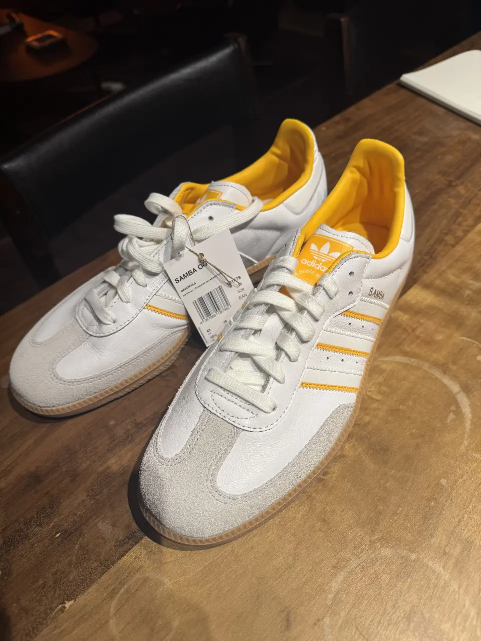 Zapatillas Adidas Samba OG blancas con detalles amarillos.