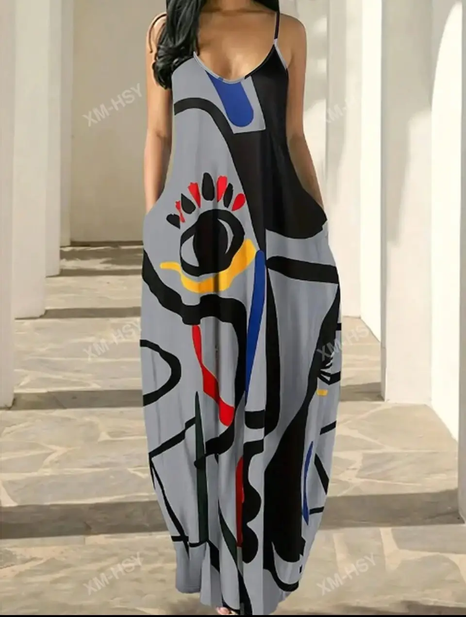 Vestido largo de mujer con estampado abstracto en tonos grises, negros, rojos, amarillos y azules. Diseño con tirantes finos y bolsillos laterales. Ideal para un look moderno y artístico.