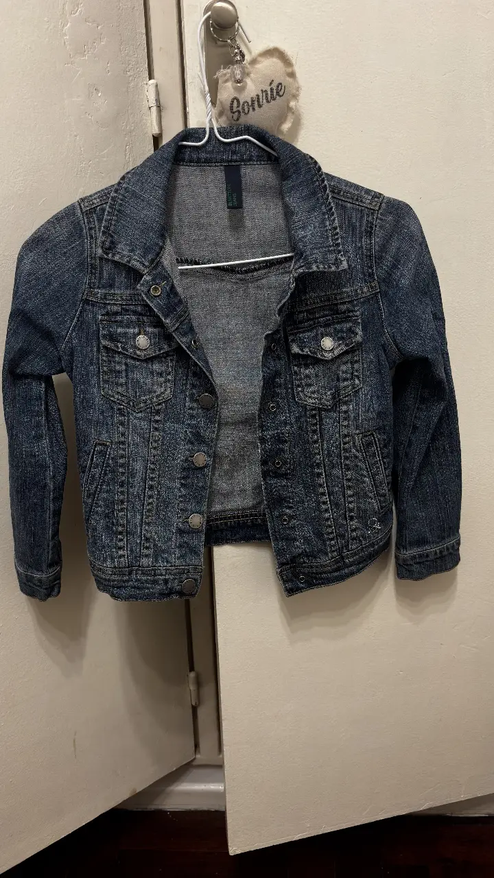Campera de jean azul oscuro para niña o niño, con botones y bolsillos delanteros. Ideal para un look casual y moderno.