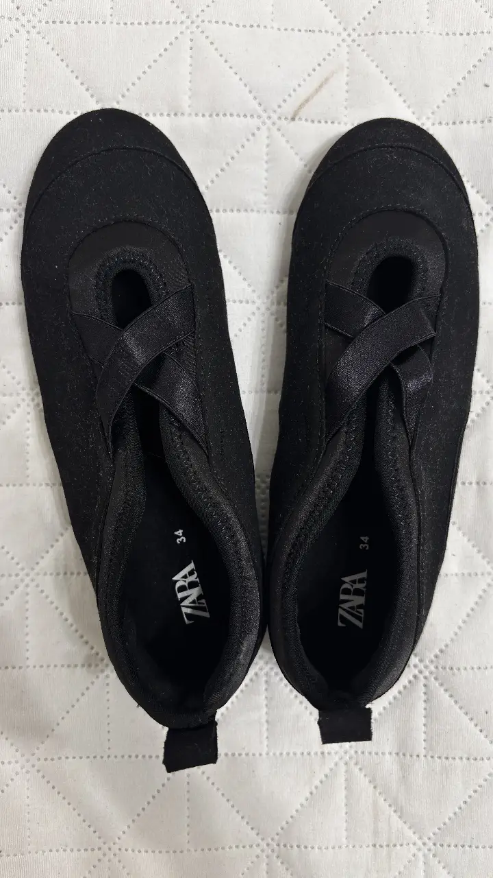 Zapatillas negras de tela, con diseño de slip-on y detalle de tiras cruzadas. Marca Zara, talle 34. Sin uso.