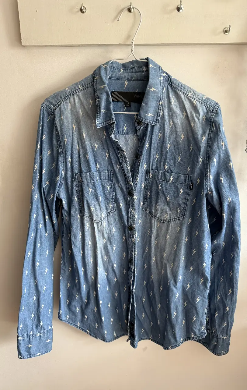 Camisa de jean azul con estampado de rayos blancos. Marca Vans. Talle M. Ideal para un look casual y canchero.