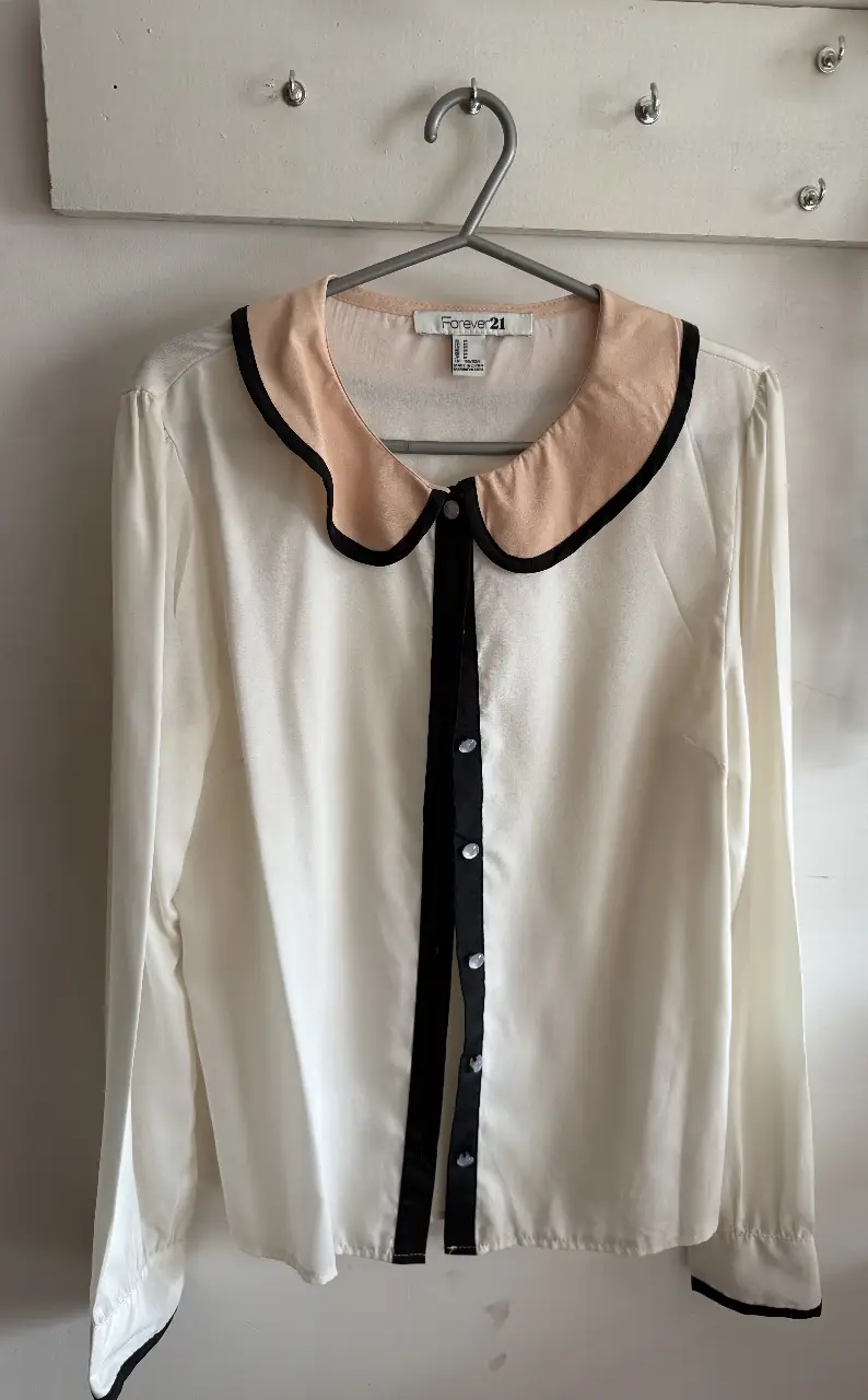 Blusa de mujer Forever 21, blanca con cuello y detalles en negro y rosa. Ideal para un look elegante y sofisticado.