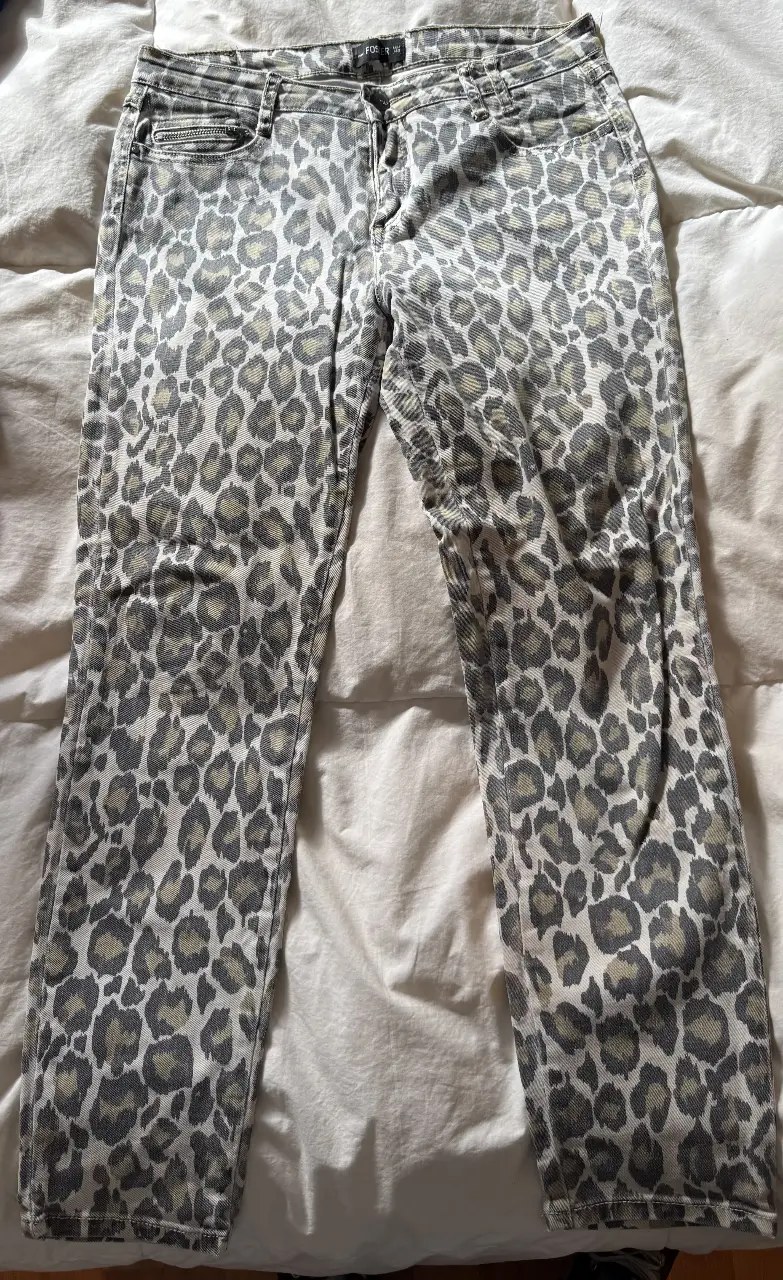 Jeans rectos con estampado de leopardo en tonos grises y blancos. Tiro medio, ideales para un look casual y canchero.