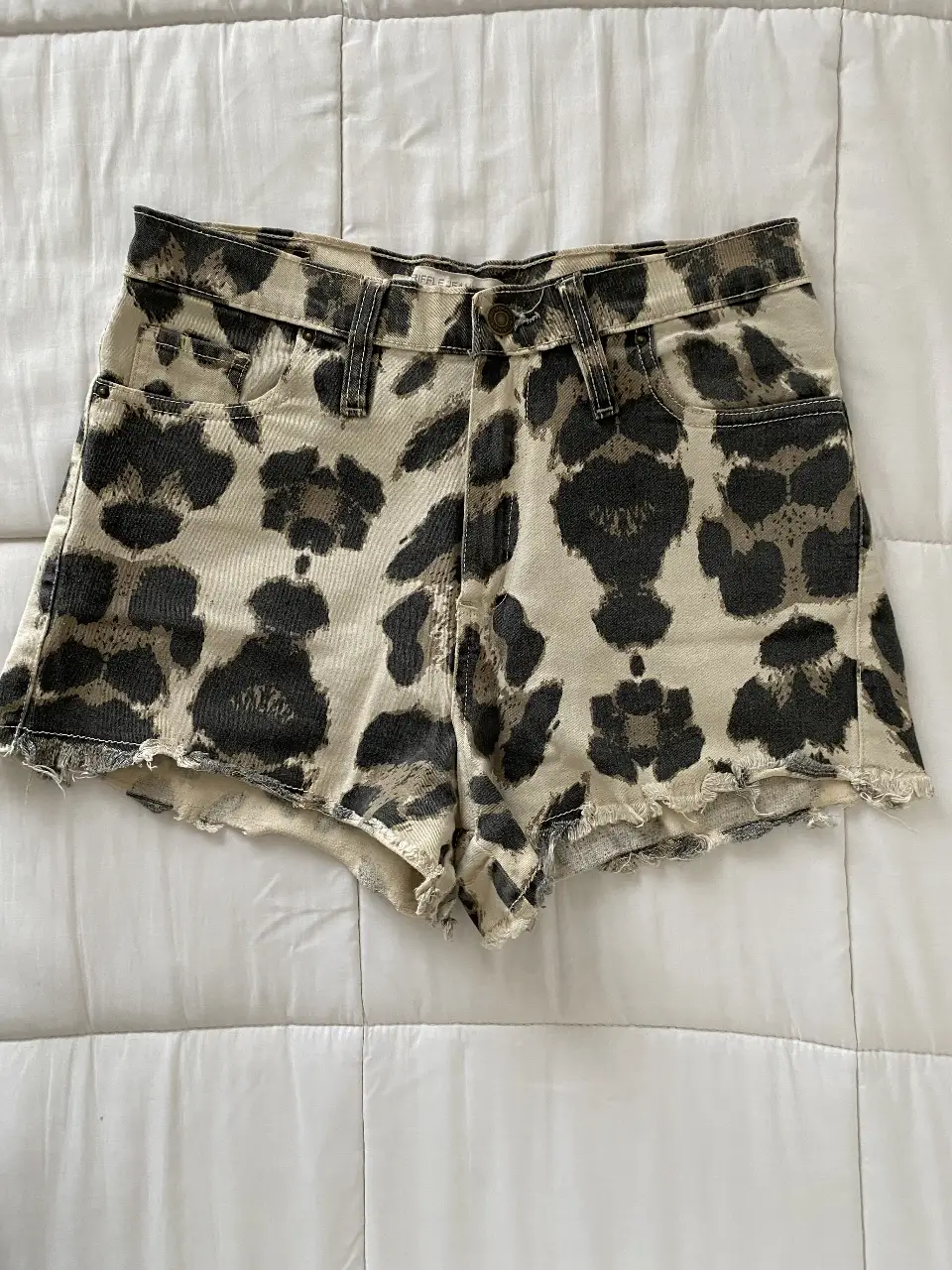 Short de jean tiro alto con estampado de leopardo en tonos crudo y negro. Ideal para un look casual y canchero.
