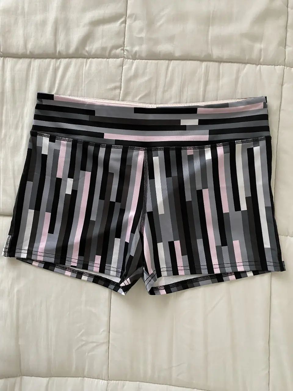 Calza deportiva corta Forever 21 con estampado geométrico en tonos grises, negro y rosa, con cierre trasero. Ideal para actividades físicas.