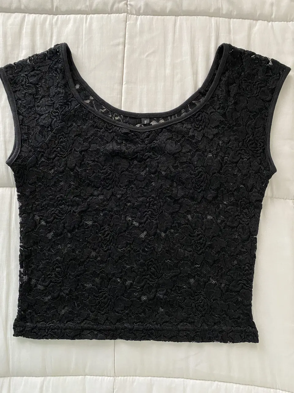 Top de encaje negro, ideal para una salida o para combinar con un look casual. Diseño delicado y femenino.