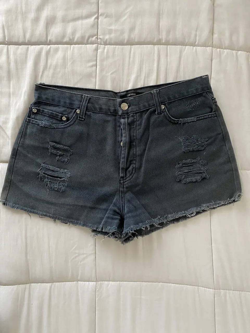 Short de jean Forever 21 negro gastado con roturas, tiro medio y corte desflecado. Ideal para un look casual y canchero.