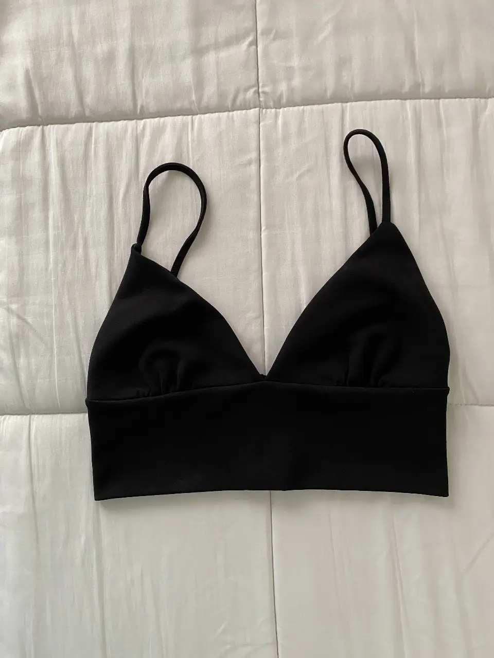 Top negro con breteles finos, ideal para combinar con cualquier outfit. Perfecto para un look casual o para usar debajo de otras prendas.