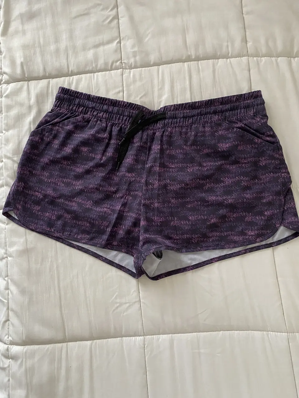 Short deportivo de mujer marca Fila original, con estampado en tonos violetas y negro. Ideal para actividades físicas.