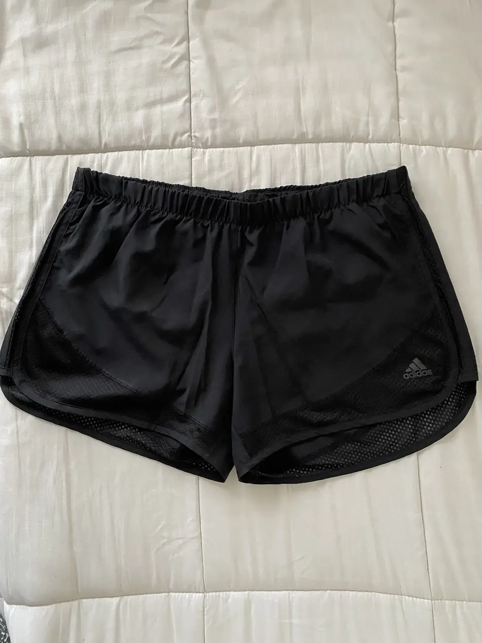 Short deportivo negro Adidas original para running, con detalles de malla y logo de la marca. Ideal para tus entrenamientos.