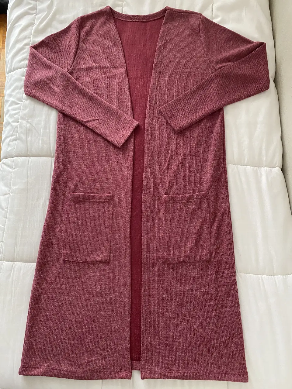 Cardigan largo de mujer en color borgoña, con dos bolsillos delanteros. Ideal para un look casual y cómodo.