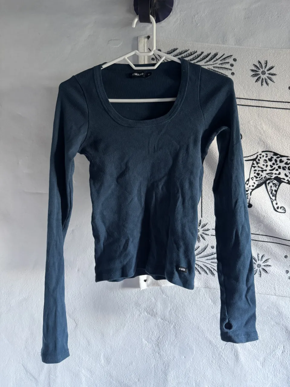 Remera de manga larga, escote redondo, de tejido acanalado. Tiene agujeros en las mangas para el pulgar