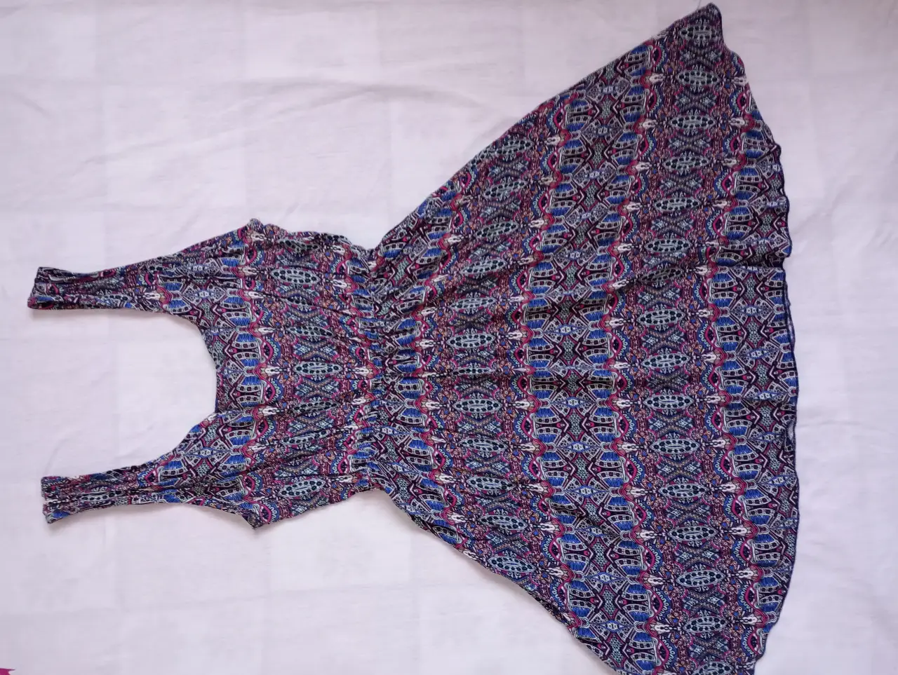 Vestido midi con estampado geométrico en tonos azules y detalles en rosa. Ideal para un look casual y fresco.