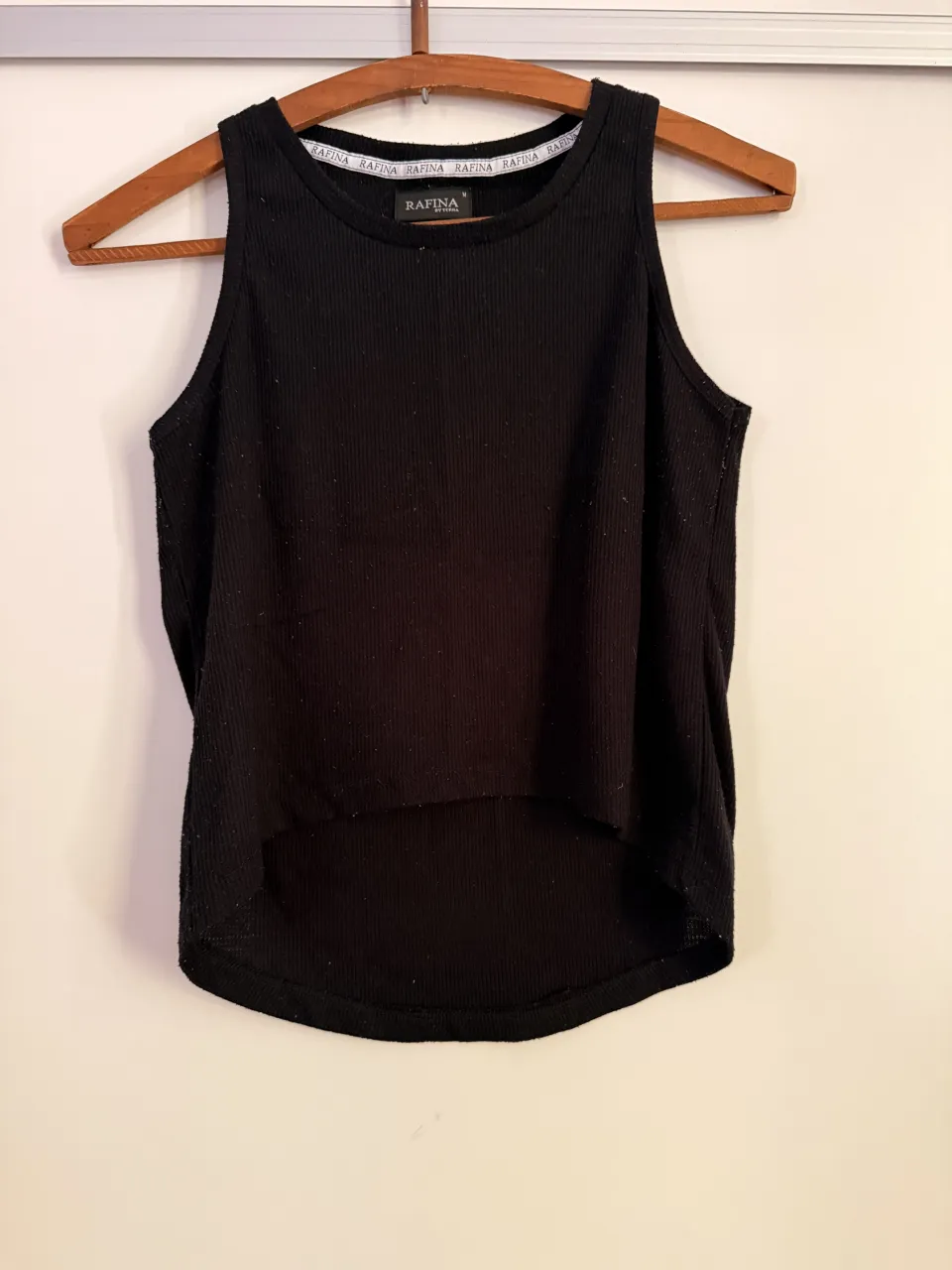 Musculosa negra de tejido acanalado. Posee cuello redondo y la parte inferior tiene un corte curvo. tiene bolitas por su uso. el precio es charlable.