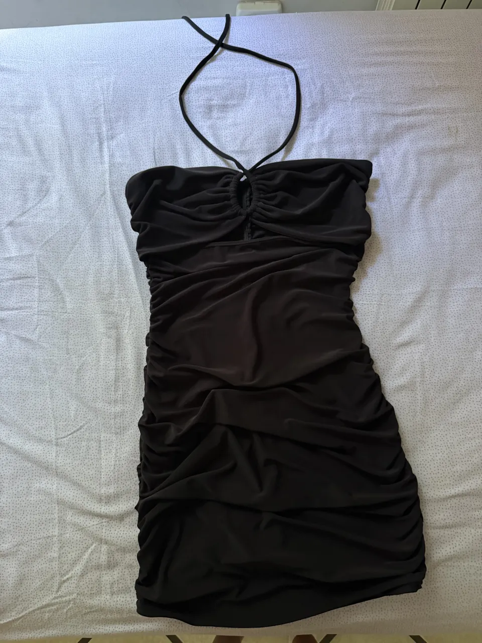 Vestido negro súper canchero, ideal para salir de fiesta o para un evento especial. Tiene un diseño fruncido que estiliza la figura y un escote halter que le da un toque súper sexy. ¡No te lo pierdas!