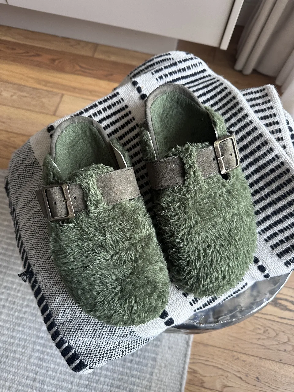 Zuecos de peluche verde, ideales para estar cómoda en casa. Diseño moderno y abrigado, perfectos para el invierno. Calzado de mujer, estilo pantufla.
