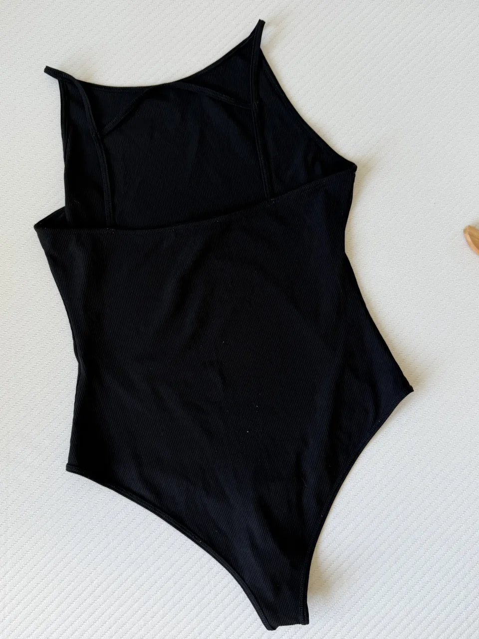 Body negro de morley, con breteles finos y escote cuadrado. Espalda con tiras cruzadas.