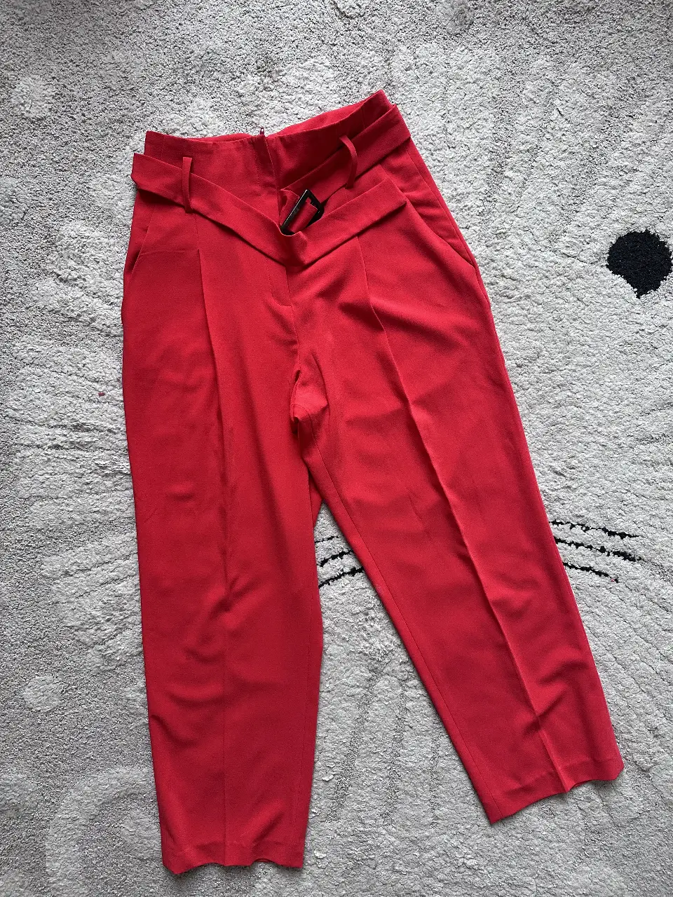 Pantalón sastrero rojo de mujer, con detalle de cinturón y hebilla. Ideal para un look elegante y moderno.