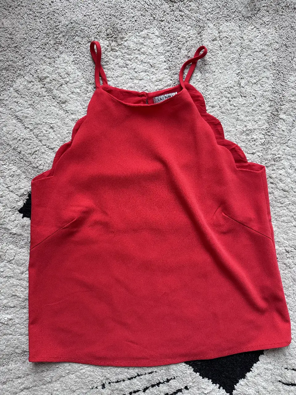 Top rojo con detalle de volados en el escote y tirantes finos. Ideal para un look fresco y moderno.