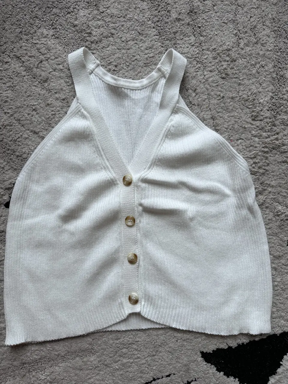 Top tejido blanco con botones. Ideal para un look casual y cómodo.