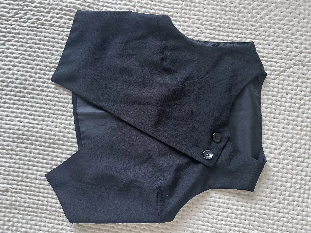 Chaleco sastrero negro, con dos botones y corte elegante. Ideal para looks formales o para darle un toque sofisticado a cualquier outfit.