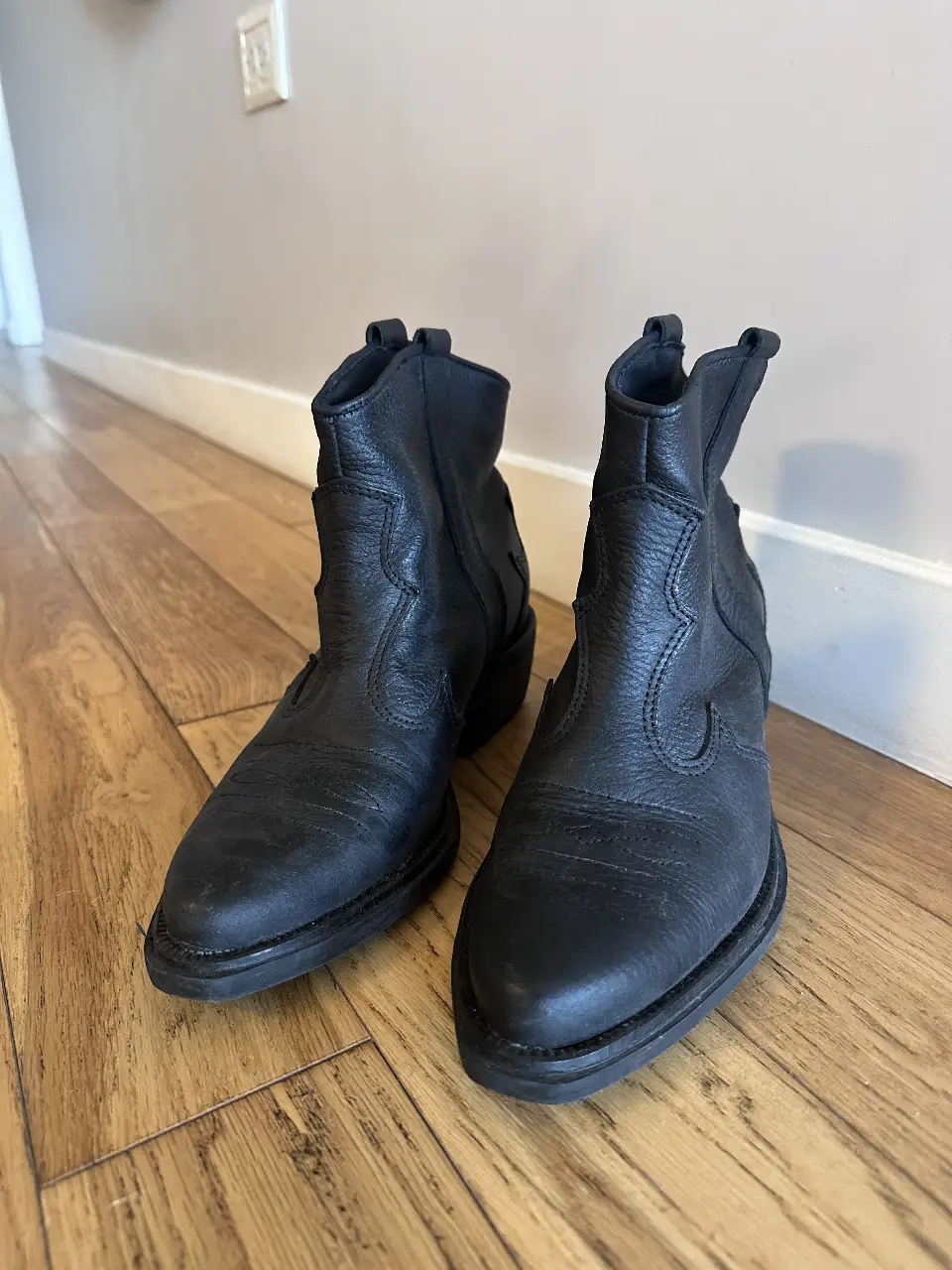 Botines de cuero negro, estilo cowboy, con detalles de costura y diseño en el lateral. Talle 37.