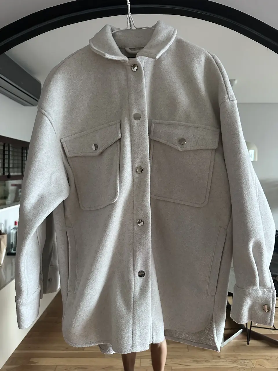 Campera tipo camisa de Zara, color gris claro, con dos bolsillos delanteros y botones plateados. Ideal para un look casual y moderno.