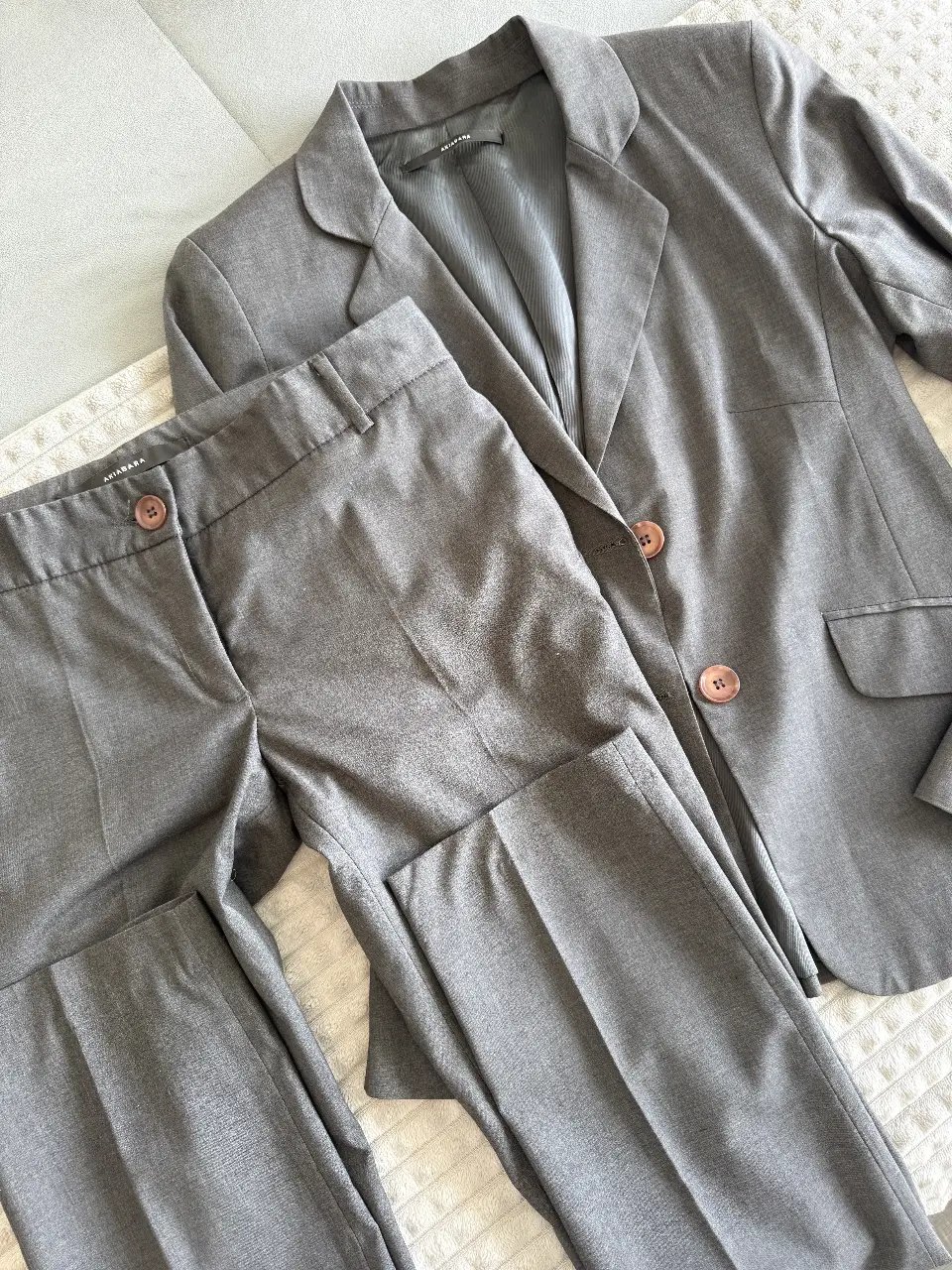 Traje sastrero gris para mujer, incluye pantalón tiro bajo y blazer con frunce en espalda. Ideal para un look formal y elegante.