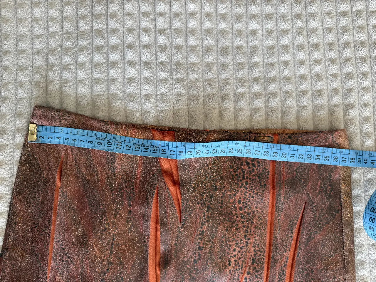 Pollera midi con estampado animal print en tonos marrones y detalles en naranja. Marca Ossira.