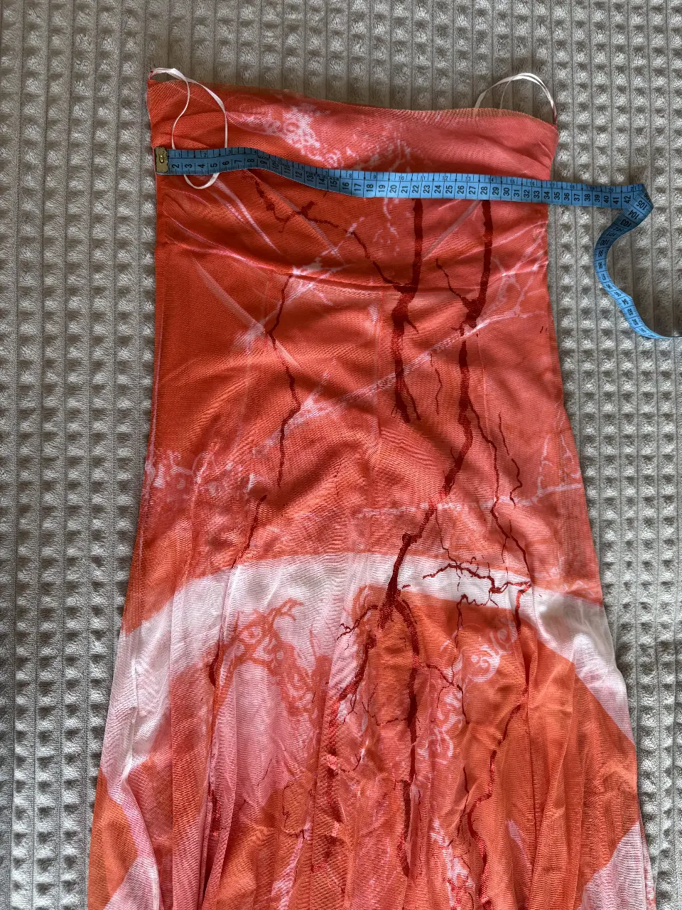 Vestido midi strapless de microtul con estampado abstracto en tonos naranja y blanco. Ideal para un look Y2K o de fiesta.